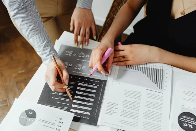 Two professionals reviewing analytical charts and data, highlighting key insights for B2B Project Management.