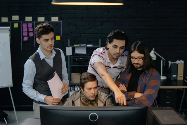 A diverse team collaborates on a computer screen to optimize Project Management in Netherlands.