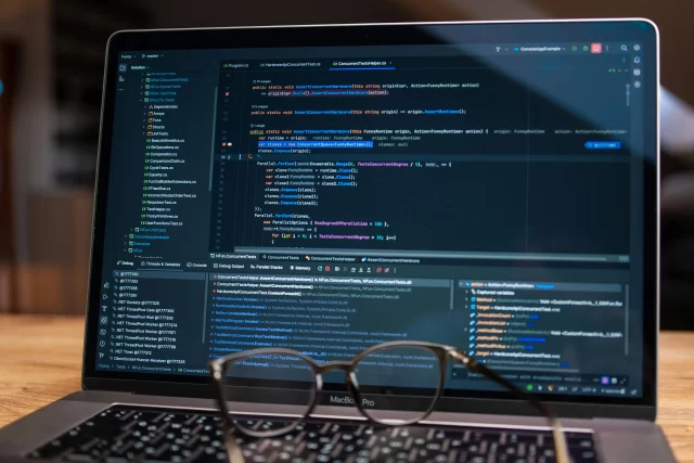 A MacBook Pro displaying C# source code in an IDE, reflecting technical workflows for Project Management in Netherlands.
