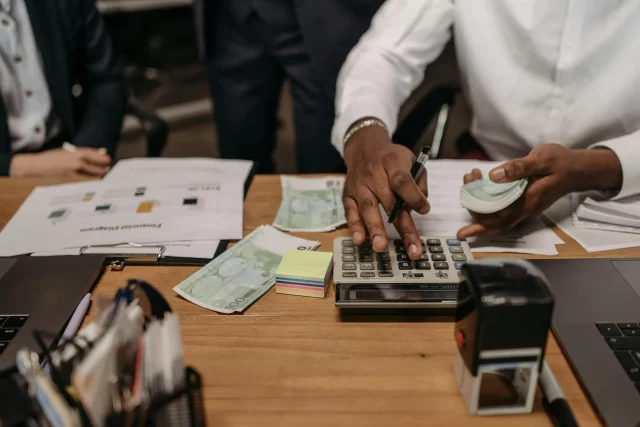 Professional working with currency and a calculator to illustrate Project Management in Banking.