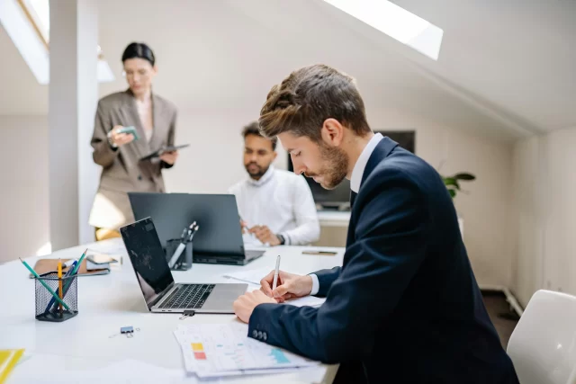Colleagues collaborating in a modern office to refine their PMO strategy.