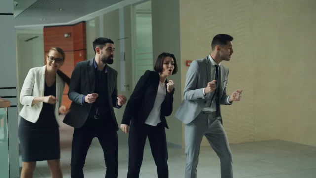 Four colleagues in business attire celebrating their success, demonstrating effective Collaboration in Project Management.