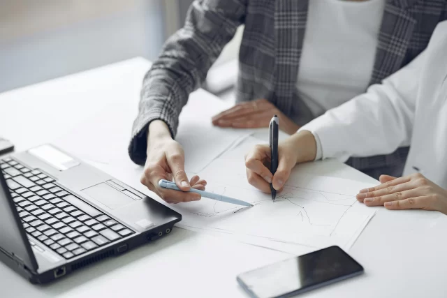 Two business professionals collaborating on a strategy document to support efficient Project and Management.