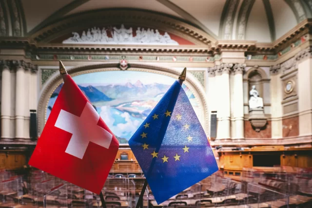 Swiss and European Union flags placed in the Swiss parliament for an IT Consulting strategy session.