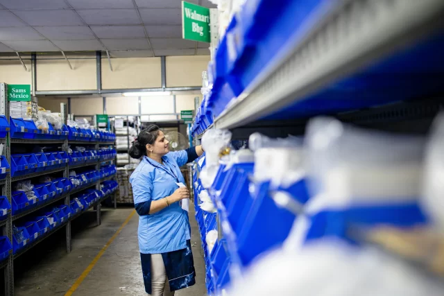 Warehouse worker picking items from shelves to support efficient Supply and Chain Management.