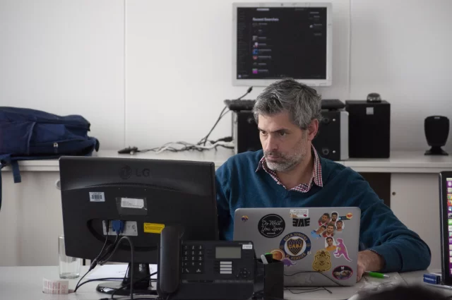 A focused professional working on a laptop in an office environment to implement Scrum in Switzerland.