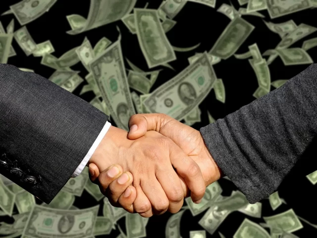 Two business professionals shaking hands, symbolizing successful Swiss supply and chain management.